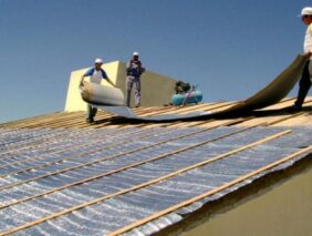 Trabajadores colocando aislantes termicos sobre una cubierta para optimizar el aislamiento y el confort interior de la construccion